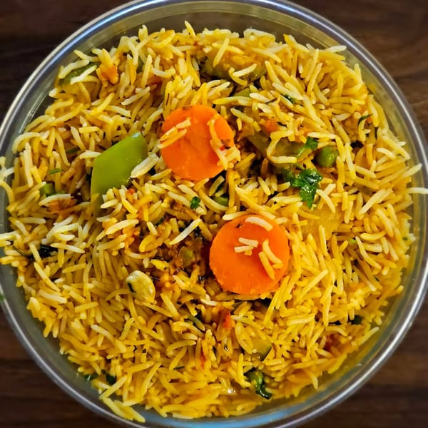 Close-up of Taj Mahal Homestyle Indian and Pakistani Cuisine's vegetable biryani with carrots, peas, and peppers.